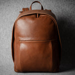 Brown leather backpack on a gray background