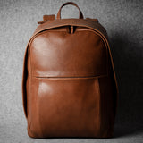 Brown leather backpack on a gray background