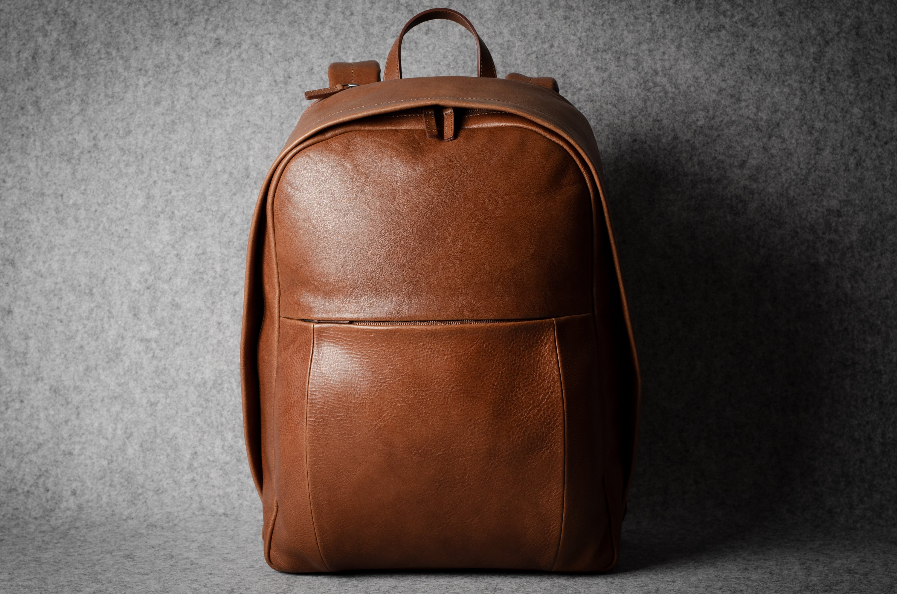 Brown leather backpack on a gray background