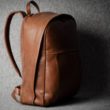 Brown leather backpack on a gray background