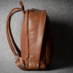 Brown leather backpack on a gray background