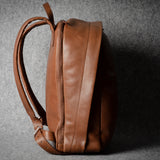 Brown leather backpack on a gray background
