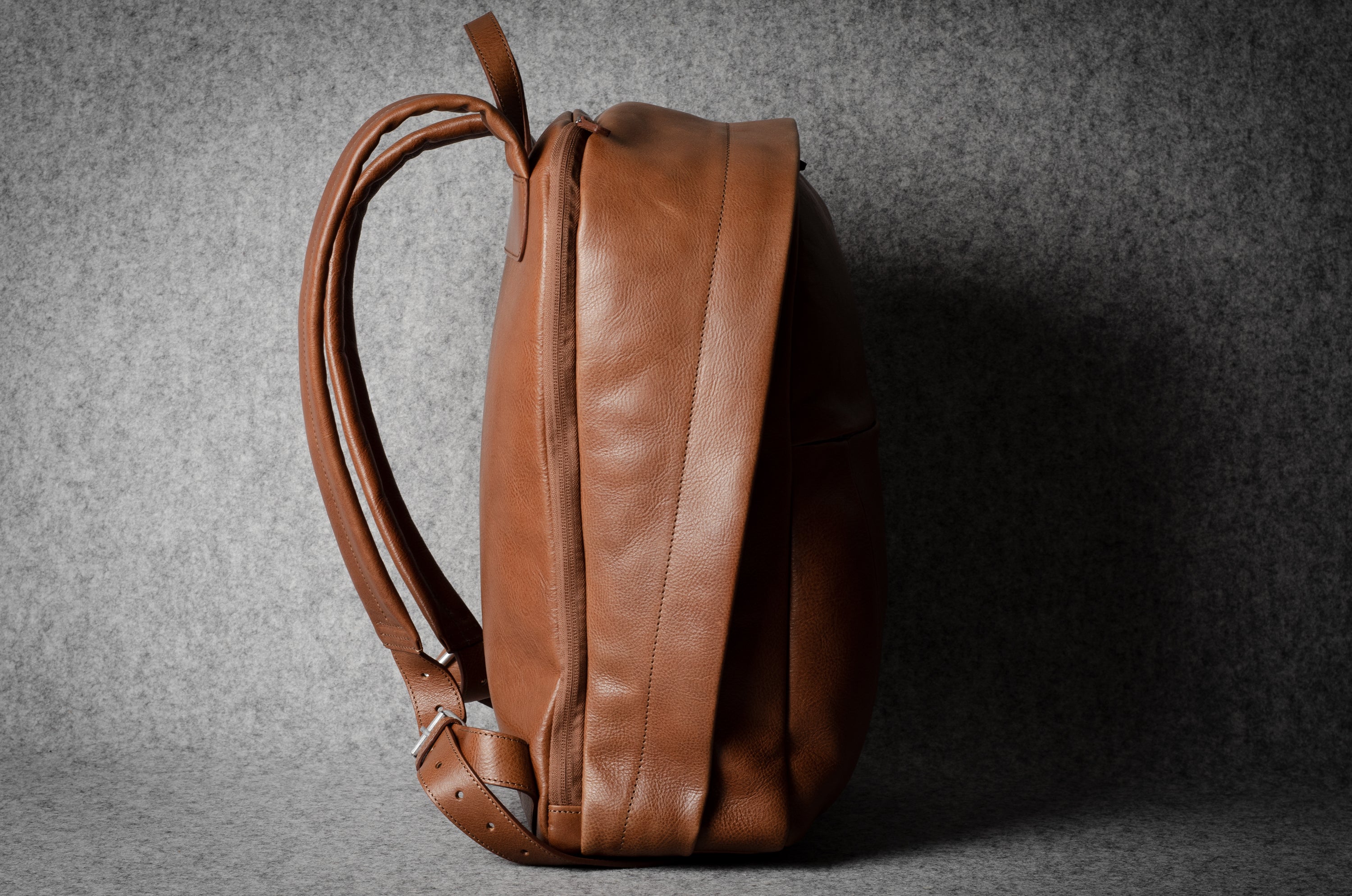 Brown leather backpack on a gray background