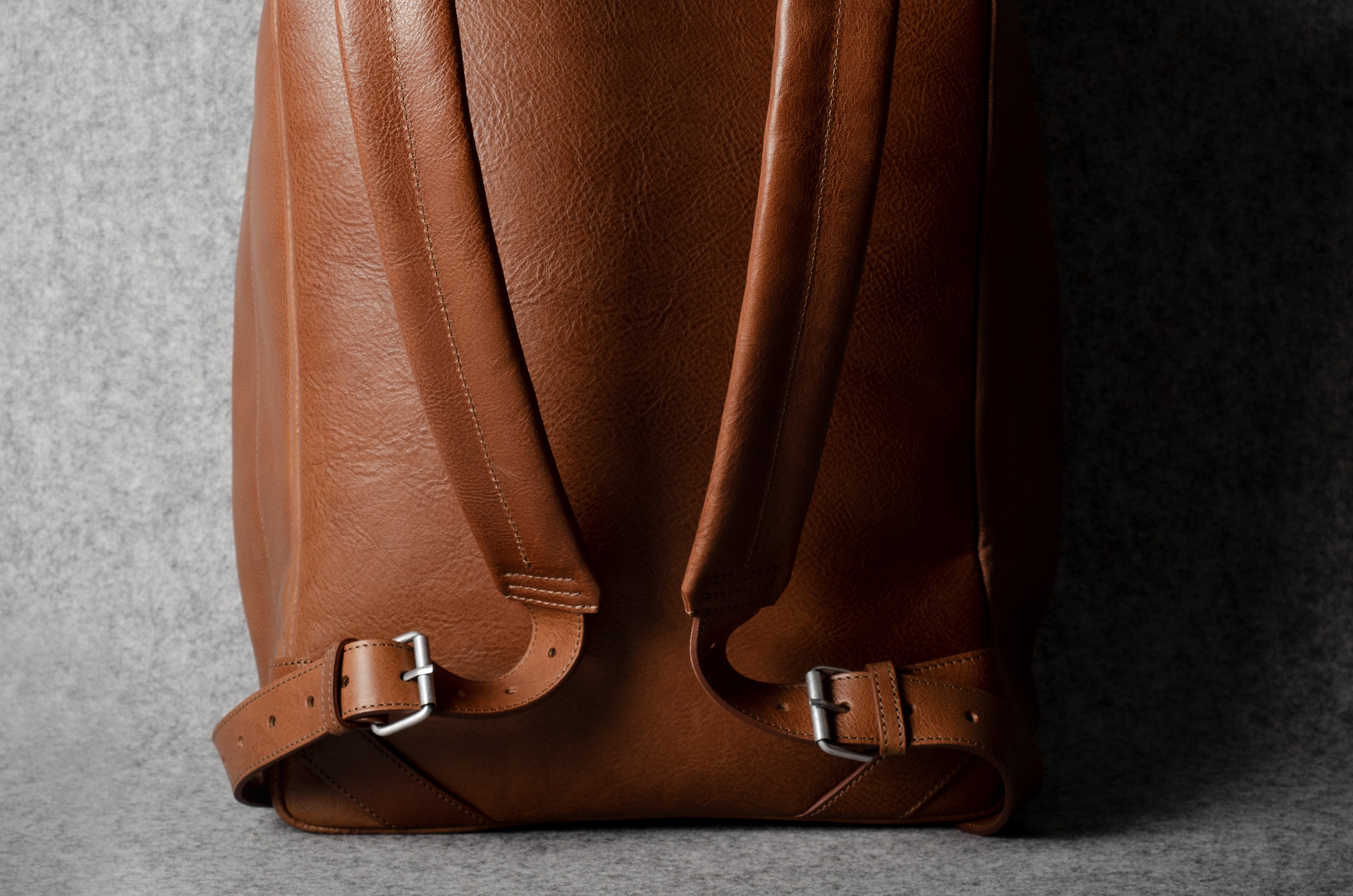 Brown leather backpack on a gray background