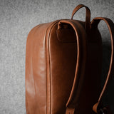 Brown leather backpack on a gray background