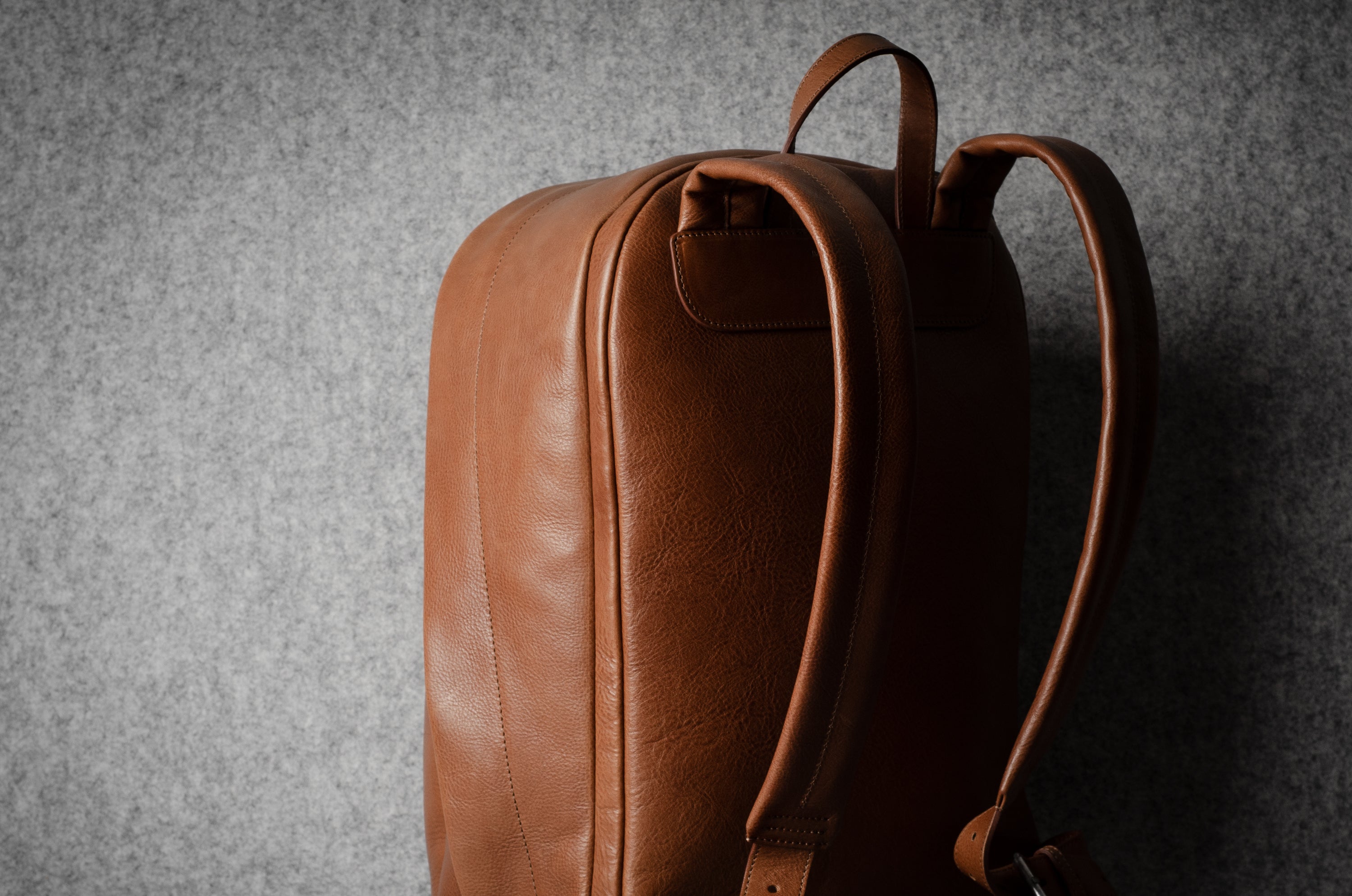 Brown leather backpack on a gray background