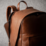 Brown leather backpack on a gray background