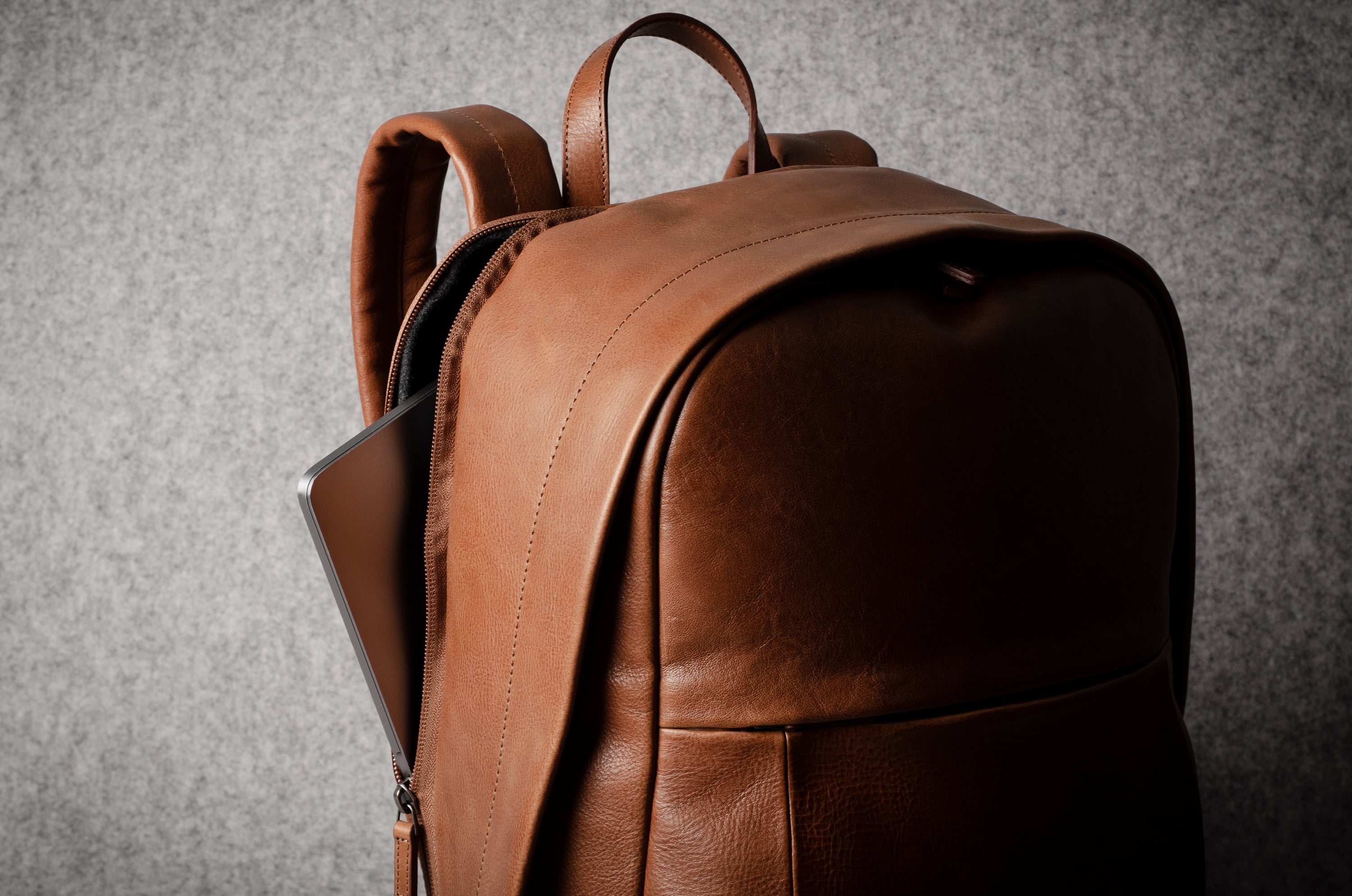 Brown leather backpack on a gray background