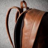 Brown leather backpack on a gray background