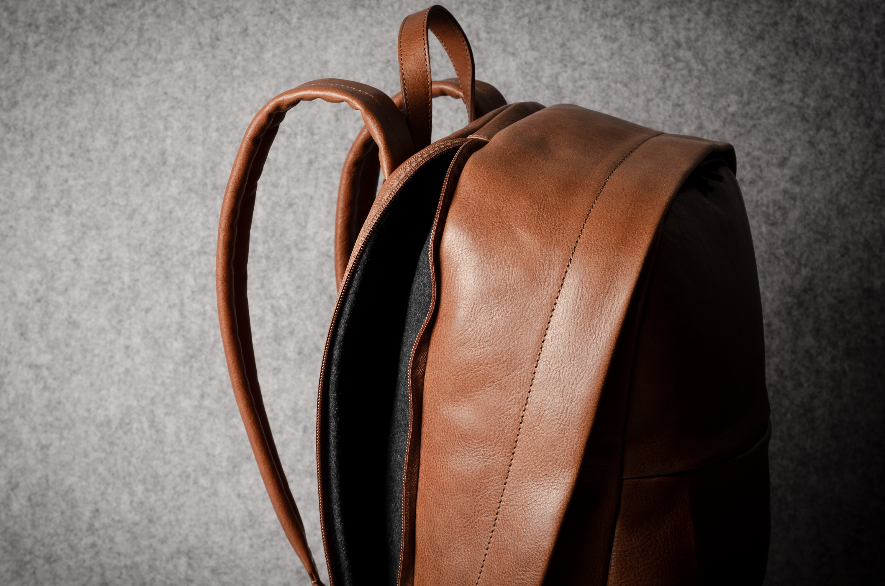 Brown leather backpack on a gray background