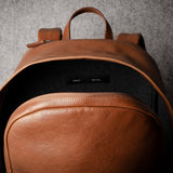 Brown leather backpack on a gray background