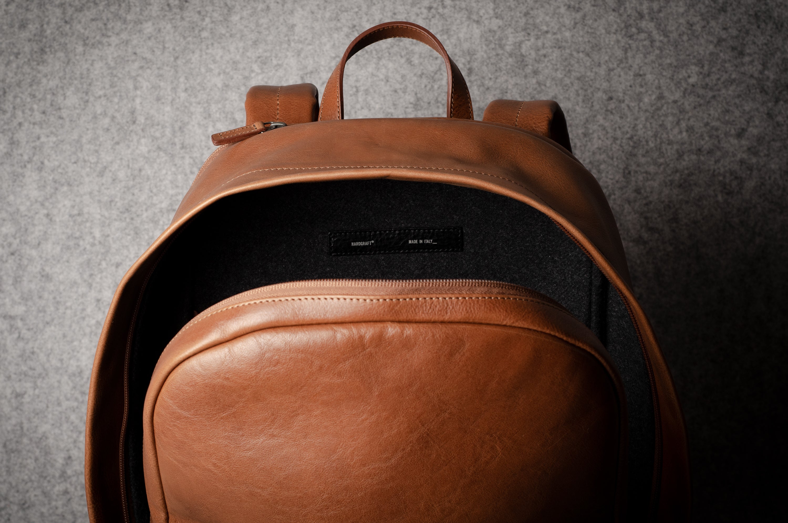 Brown leather backpack on a gray background