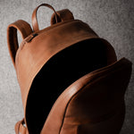 Brown leather backpack on a gray background