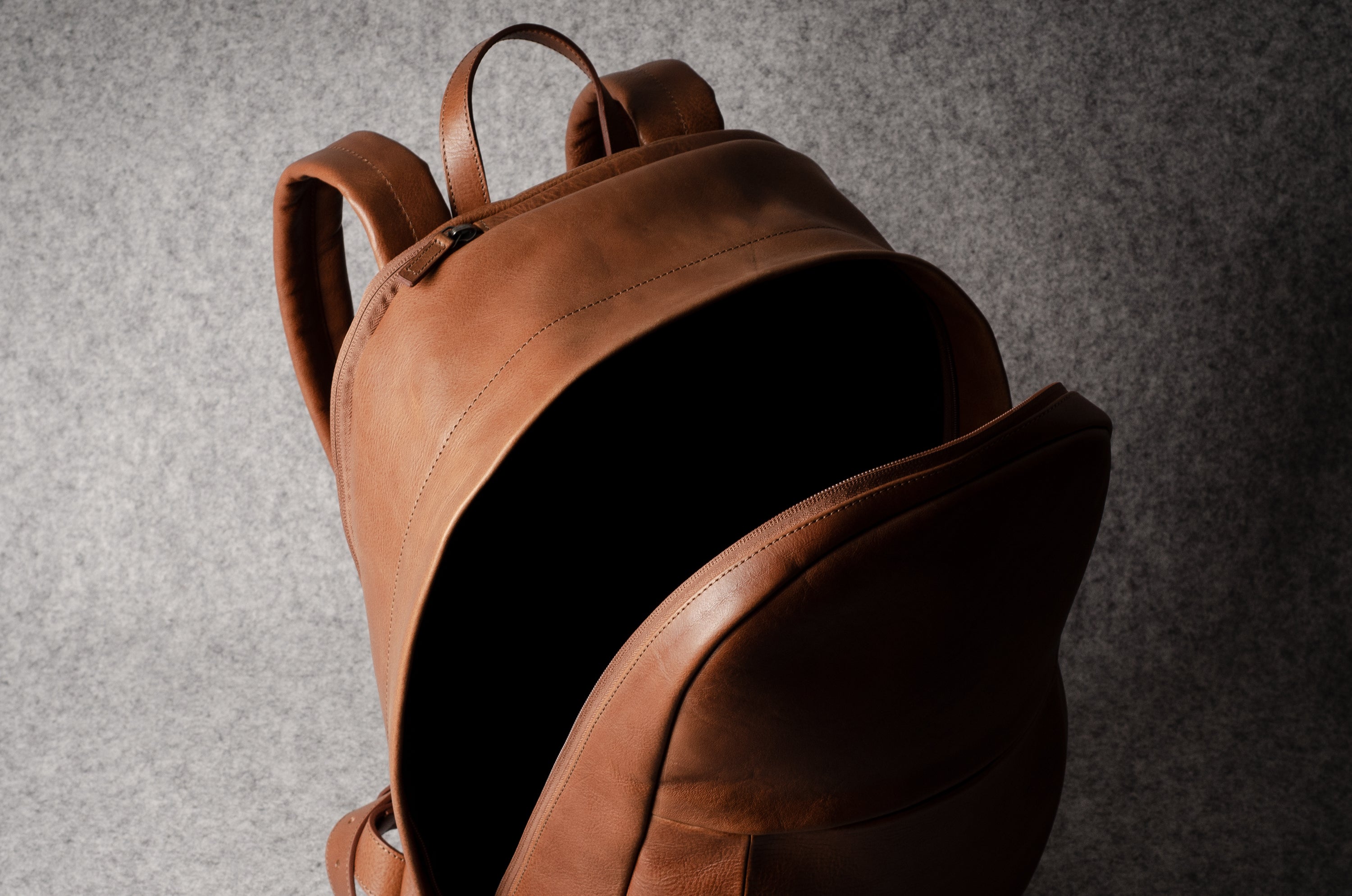 Brown leather backpack on a gray background