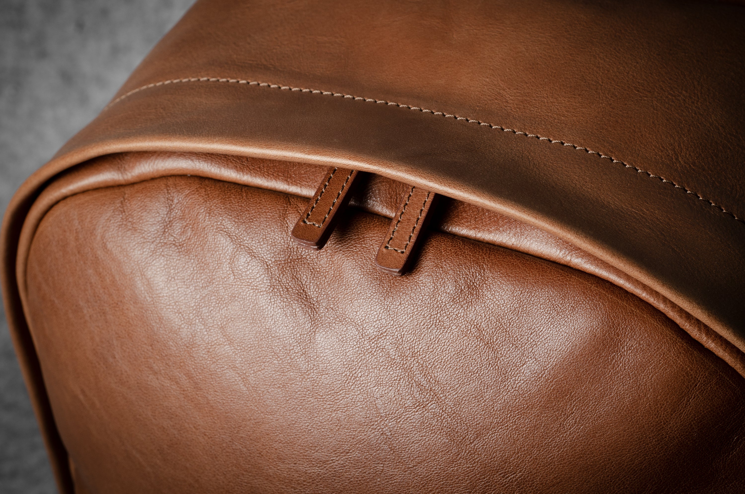 Close-up of a brown leather backpack with visible stitching