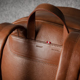 Brown leather backpack on a gray background