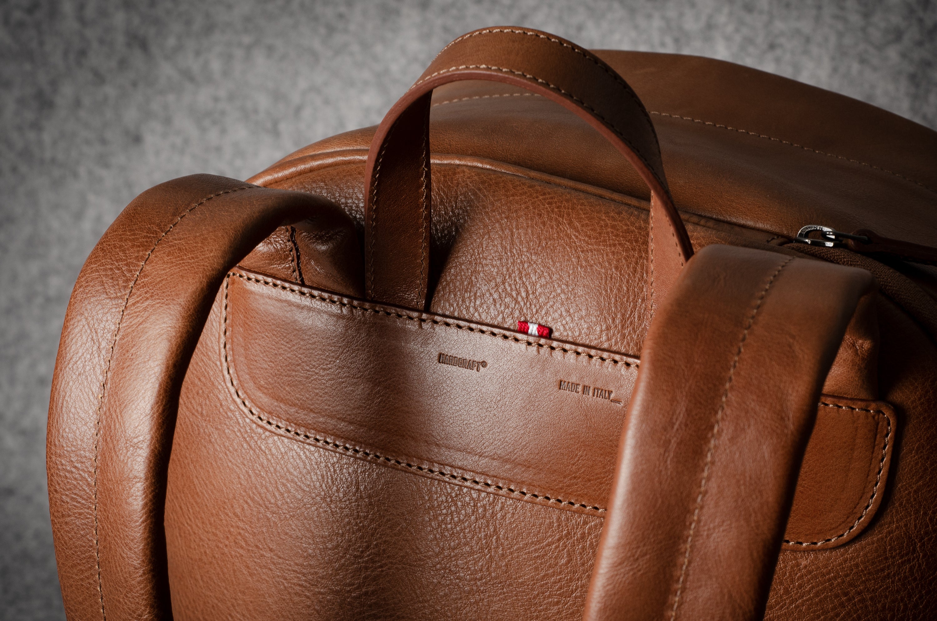 Brown leather backpack on a gray background