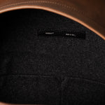 Close-up of a leather backpack with a hardgraft label on a dark background