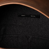Close-up of a leather backpack with a hardgraft label on a dark background