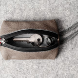 Pochette à clés zippée. Gris cassé