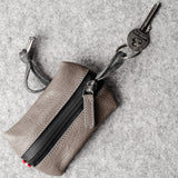 Pochette à clés zippée. Gris cassé