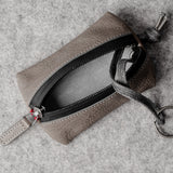 Pochette à clés zippée. Gris cassé