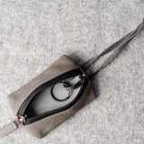 Pochette à clés zippée. Gris cassé