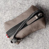 Pochette à clés zippée. Gris cassé