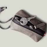 Pochette à clés zippée. Gris cassé